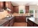Gourmet kitchen featuring granite countertops, dark cabinetry, stainless steel appliances, and gas cooktop at 4830 Northridge Dr, Cumming, GA 30041