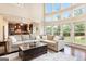 Spacious living room with large windows, hardwood floors, and an open layout to the kitchen at 4830 Northridge Dr, Cumming, GA 30041