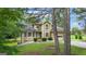 View of a charming two-story home with an attached two-car garage framed by mature trees at 115 Rockhurst Chase, Tyrone, GA 30290