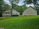 Expansive backyard featuring a well-maintained lawn, deck, and detached garage in a tranquil, wooded setting at 460 Hilo Rd, Fayetteville, GA 30215