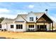 The back of a home with a covered porch, featuring a dining area and a seating area at 25 Oak Rd, Locust Grove, GA 30248