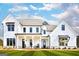 Stunning two-story white farmhouse with covered front porch and well-manicured lawn at 25 Oak Rd, Locust Grove, GA 30248