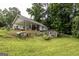 Spacious covered patio, retaining wall and sheds on a lush green lawn, ideal for outdoor living and entertaining at 300 Peggy Cole Bridge Rd, Villa Rica, GA 30180