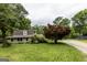 A lovely home is nestled among trees, with a brown roof and green lawn, with solar panels in the back at 300 Peggy Cole Bridge Rd, Villa Rica, GA 30180