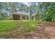 Backyard features a well-manicured lawn, mature trees, and a home with a cozy screened-in porch at 40 Riverside Pkwy, Sharpsburg, GA 30277