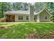 Landscaped backyard with a well-maintained lawn, mature trees, and a home with a chimney at 40 Riverside Pkwy, Sharpsburg, GA 30277