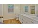 Bathroom featuring a double vanity, mirror, toilet, window, and wood flooring at 40 Riverside Pkwy, Sharpsburg, GA 30277