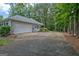 Home exterior with a spacious driveway, attached garage, and mature trees offers ample parking at 40 Riverside Pkwy, Sharpsburg, GA 30277