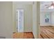 Hallway view of a bathroom and main bedroom with wood floors and natural light at 40 Riverside Pkwy, Sharpsburg, GA 30277