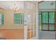 View from a living room to a screened porch featuring a chandelier and door to a wooded area at 40 Riverside Pkwy, Sharpsburg, GA 30277
