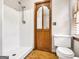 Clean bathroom with a stand-up shower and a toilet, featuring wood-style flooring and neutral wall colors at 2306 Old Lower River Rd, Douglasville, GA 30135