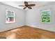 Bedroom with hardwood floors, neutral walls, a ceiling fan, and natural light from two windows at 2306 Old Lower River Rd, Douglasville, GA 30135