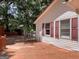 Exterior view shows a back deck and charming home with red trim, surrounded by lush trees at 2306 Old Lower River Rd, Douglasville, GA 30135