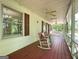 Covered front porch featuring rocking chairs and a view of the surrounding trees at 2306 Old Lower River Rd, Douglasville, GA 30135