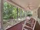 Covered front porch with rocking chairs and peaceful views of the wooded surroundings at 2306 Old Lower River Rd, Douglasville, GA 30135
