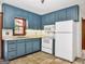 Functional kitchen featuring tile floors, ample cabinet space, and white appliances for easy meal preparation at 2306 Old Lower River Rd, Douglasville, GA 30135