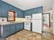 Traditional style kitchen with blue cabinets, tile floors, and white appliances at 2306 Old Lower River Rd, Douglasville, GA 30135