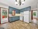 Traditional kitchen featuring blue cabinets, white appliances, and tile flooring at 2306 Old Lower River Rd, Douglasville, GA 30135