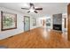 Living room with wood floors, a ceiling fan, a fireplace, and an open floorplan at 2306 Old Lower River Rd, Douglasville, GA 30135