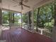 Inviting porch with a ceiling fan and a charming porch swing, offering a relaxing outdoor space among trees at 2306 Old Lower River Rd, Douglasville, GA 30135