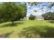 Expansive backyard with lush green lawn, mature trees, and the rear exterior of the home at 312 Cattlemans Cir, Mcdonough, GA 30252