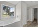 Bright bathroom with a soaking tub beneath a large window and a separate glass door shower at 312 Cattlemans Cir, Mcdonough, GA 30252