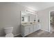 Updated primary bathroom featuring double sinks, laminate flooring, and a large mirror at 312 Cattlemans Cir, Mcdonough, GA 30252