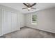 Cozy bedroom with neutral carpet, ceiling fan, large window, and closet with double doors at 312 Cattlemans Cir, Mcdonough, GA 30252