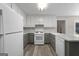 Bright kitchen featuring white and grey cabinets, stainless appliances, and a modern light fixture at 312 Cattlemans Cir, Mcdonough, GA 30252