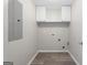 Laundry room featuring overhead cabinets, washer-dryer hookups, neutral walls, and practical flooring at 312 Cattlemans Cir, Mcdonough, GA 30252