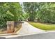 Long driveway to a brick home with manicured lawn, lush trees, and garden leading to a well kept residence at 110 Chardonnay Oaks Dr, Mcdonough, GA 30252