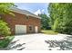 Brick home's back exterior features a two-car garage and concrete driveway at 110 Chardonnay Oaks Dr, Mcdonough, GA 30252