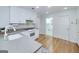 White kitchen features granite counters, ample cabinet space, and a view of the laundry room at 110 Chardonnay Oaks Dr, Mcdonough, GA 30252