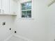 White laundry room with cabinet storage and bright natural light from a window at 110 Chardonnay Oaks Dr, Mcdonough, GA 30252