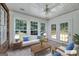 Staged sunroom with natural light, tile floors, comfortable seating, and access to deck at 110 Chardonnay Oaks Dr, Mcdonough, GA 30252