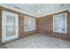 Sunroom with brick walls, tile flooring, and natural light at 110 Chardonnay Oaks Dr, Mcdonough, GA 30252