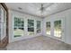 Sunroom with large windows, tile floors, white paneling and fan at 110 Chardonnay Oaks Dr, Mcdonough, GA 30252