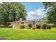 Expansive backyard with a lush green lawn, brick house, and mature trees for shade at 3212 Georgian Woods Cir, Decatur, GA 30034