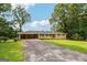 Lovely one-story home with a brick facade, carport, and a spacious front yard showcasing mature trees at 3212 Georgian Woods Cir, Decatur, GA 30034