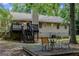 Backyard view featuring a wooden deck with stairs, mature trees, and an outdoor seating area at 1624 Hampton Locust Grove Rd, Locust Grove, GA 30248