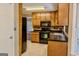Traditional kitchen with wood cabinets, black appliances, black countertops, and tile flooring at 1624 Hampton Locust Grove Rd, Locust Grove, GA 30248