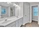 Bathroom featuring double sinks, a large mirror, and a walk-in shower at 105 Rosewood Cir, Covington, GA 30016