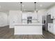 Bright kitchen features a large island, stainless steel appliances, white cabinets, and stylish pendant lights at 626 Cantrell Drive, Dallas, GA 30157