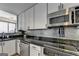 Bright kitchen with black granite counters, stainless steel appliances, and under-cabinet lighting at 285 Centennial Olympic Park Drive Northwest Nw Dr # 1905, Atlanta, GA 30339
