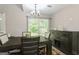 Bright dining room with modern light fixture, wood table, and sliding glass door to view the backyard at 2069 Countydown Ln, Stone Mountain, GA 30088