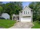 Charming two-story home with gray siding, attached garage, manicured lawn, and lovely front porch with flower accents at 2069 Countydown Ln, Stone Mountain, GA 30088