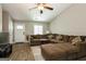 Bright living room features a ceiling fan, wood flooring, and a comfortable brown sectional with ottoman at 2069 Countydown Ln, Stone Mountain, GA 30088