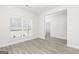 Well-lit living room featuring wood-look floors, white trim, and neutral walls, providing a blank canvas at 608 Cantrell Drive, Dallas, GA 30157