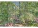 Secluded backyard retreat featuring mature trees, stone patio and outdoor furniture at 606 Wingspread, Peachtree City, GA 30269