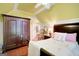Bright bedroom features hardwood floors, yellow walls and a large wardrobe at 606 Wingspread, Peachtree City, GA 30269